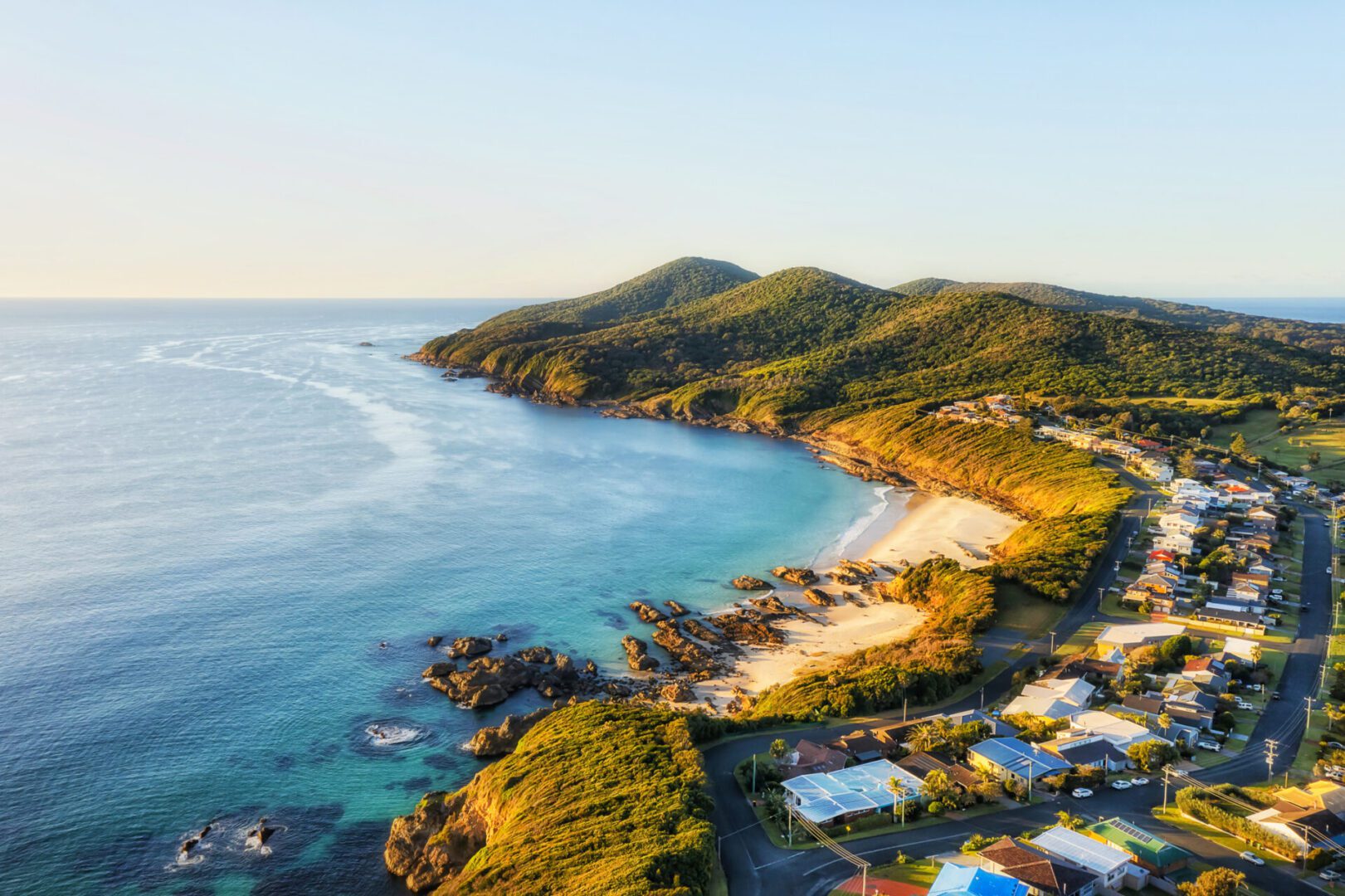 Coastal landscape with beach and houses, aerial view.