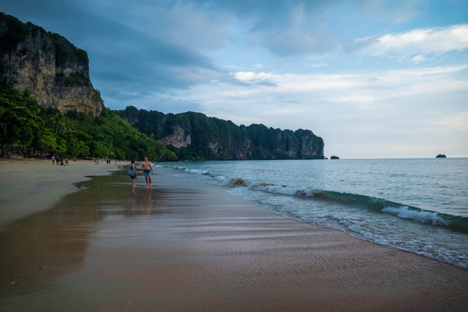 Beach with cliffs and people walking.