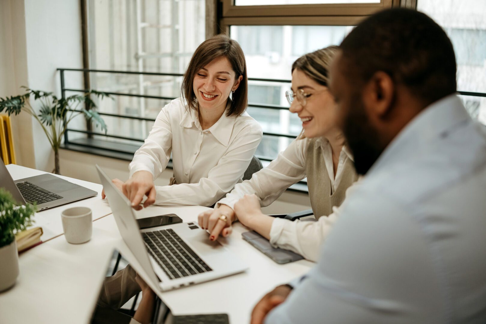 Three people collaborating at office table.
