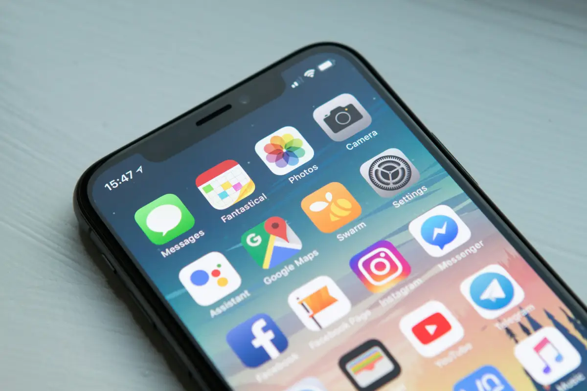 Smartphone displaying various app icons on screen.