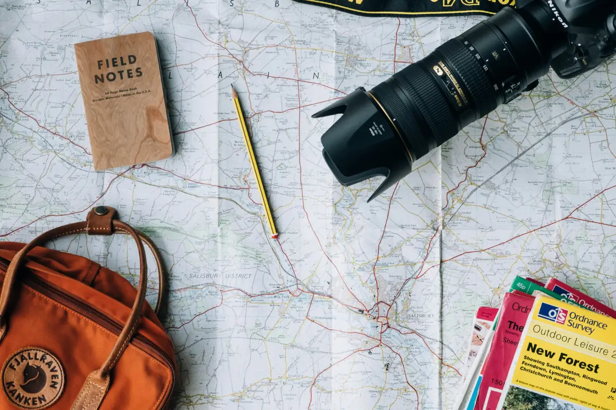 Map with camera, notebook, and bag.