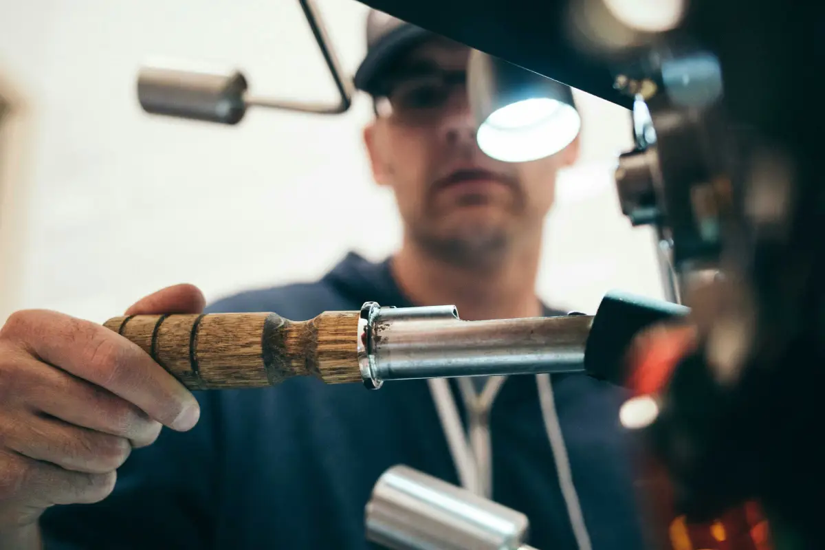 Person operating a coffee roasting machine.