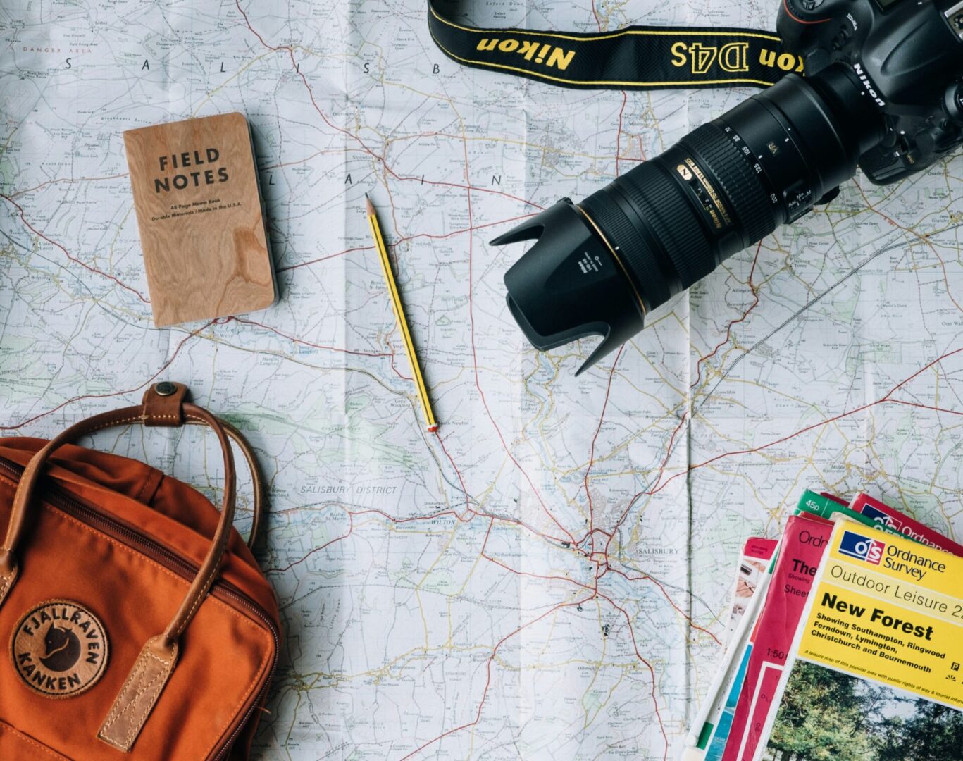 Camera, maps, and notebook on travel map.