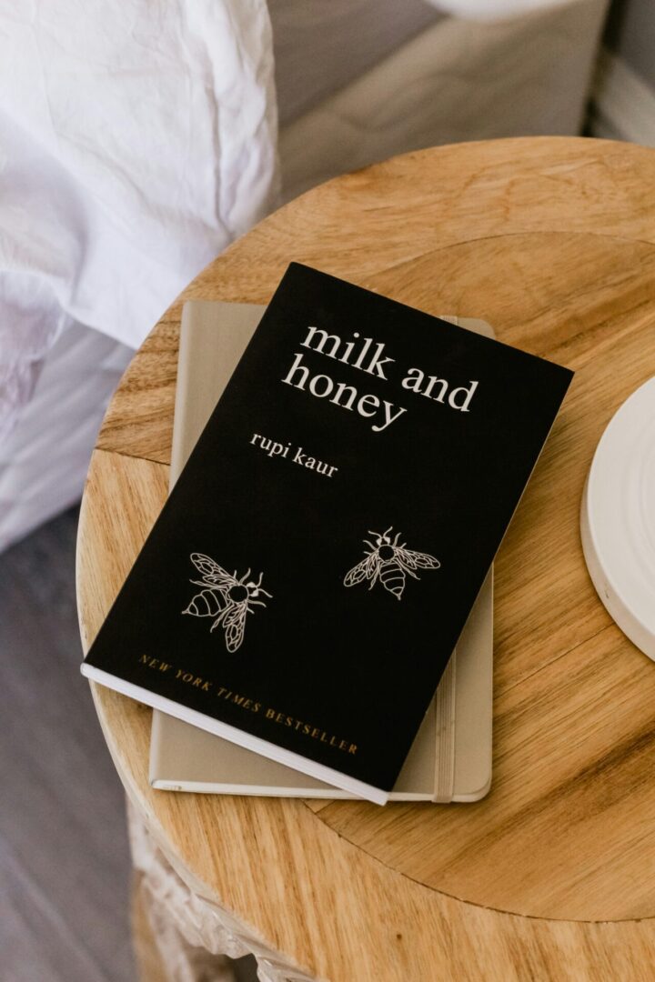 Book "Milk and Honey" on wooden table.