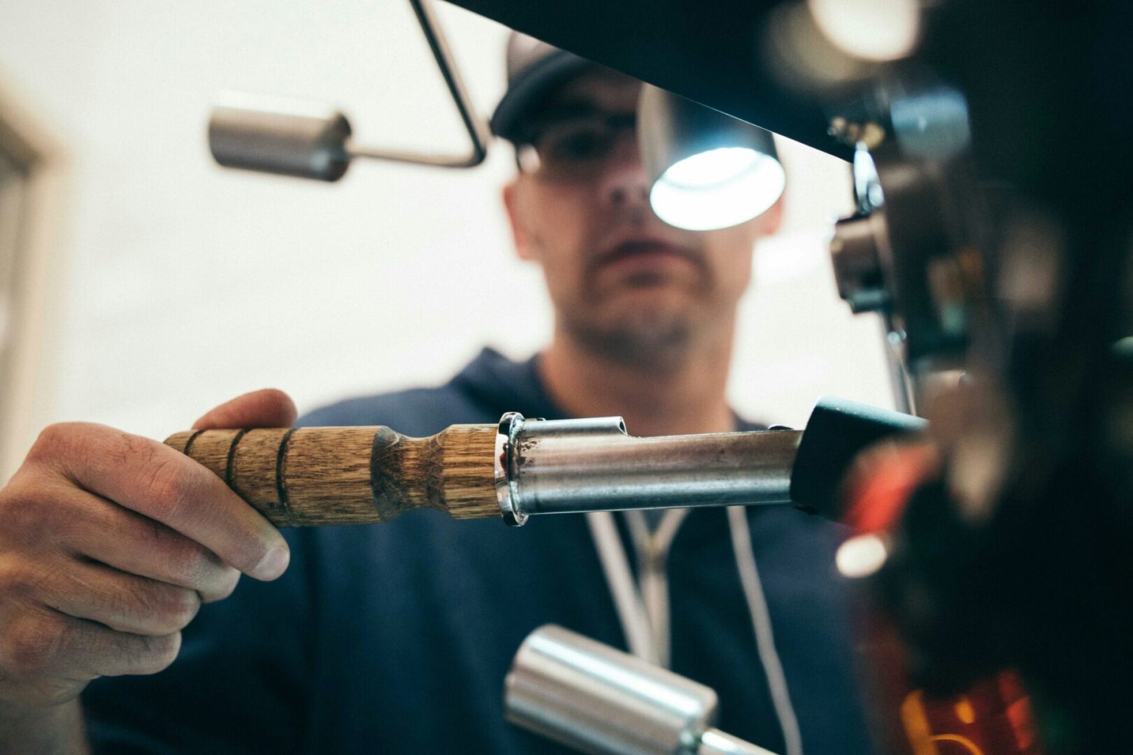 Person operating a coffee machine handle.