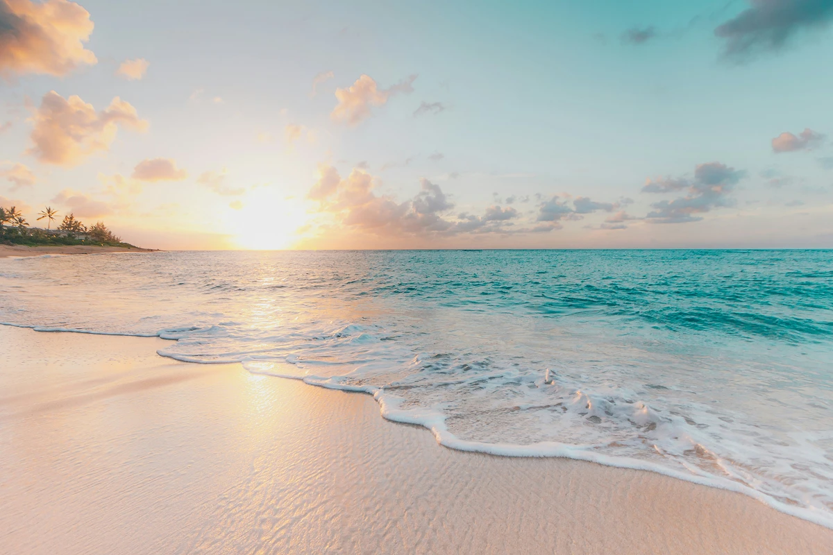 Sunset over a tranquil sandy beach.