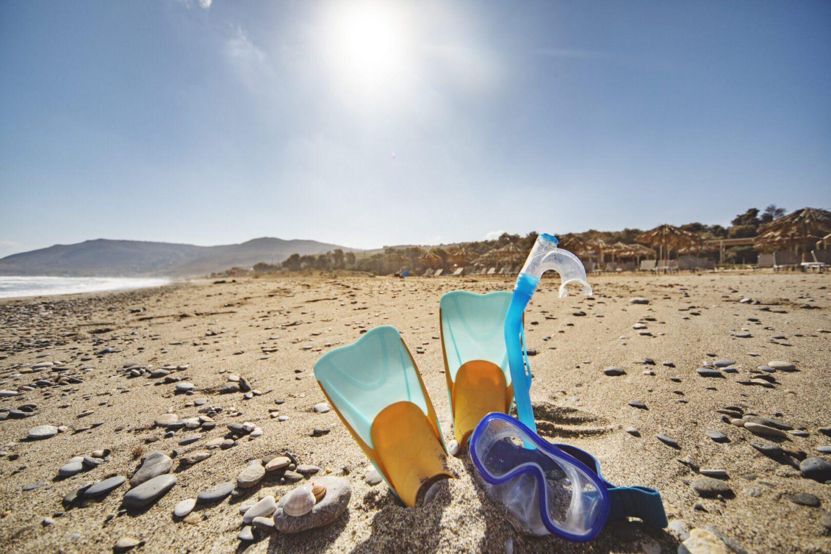 Snorkeling gear on a sunny beach.