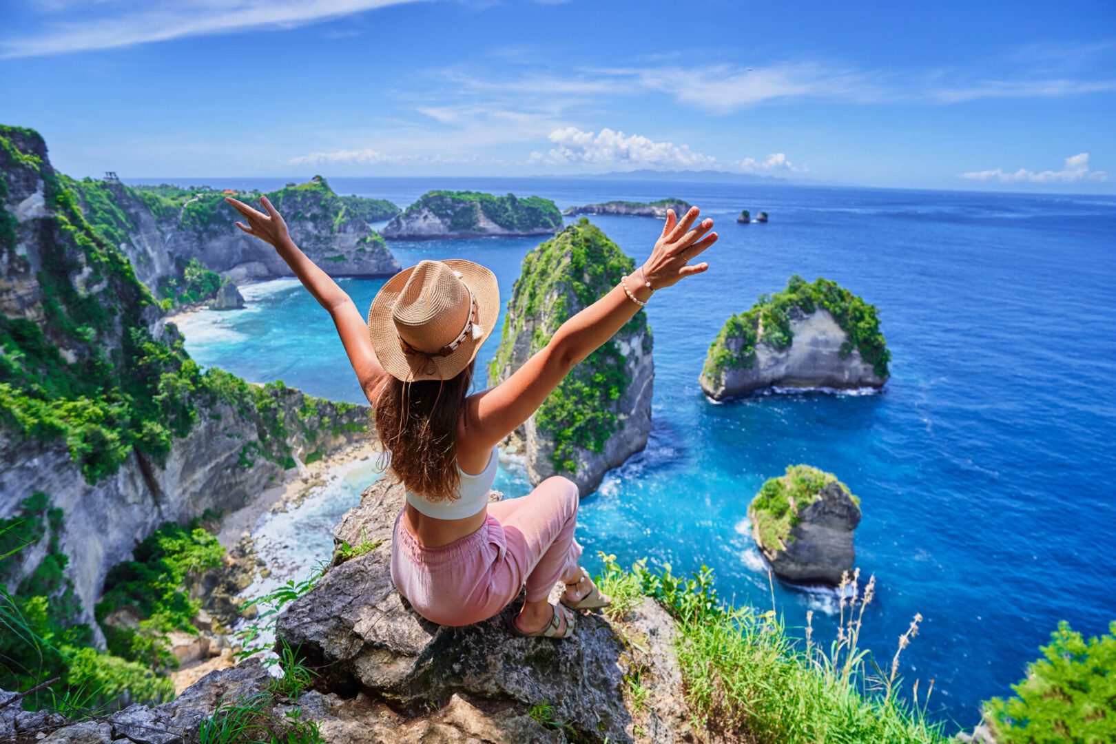 Woman enjoying ocean view from cliff edge.