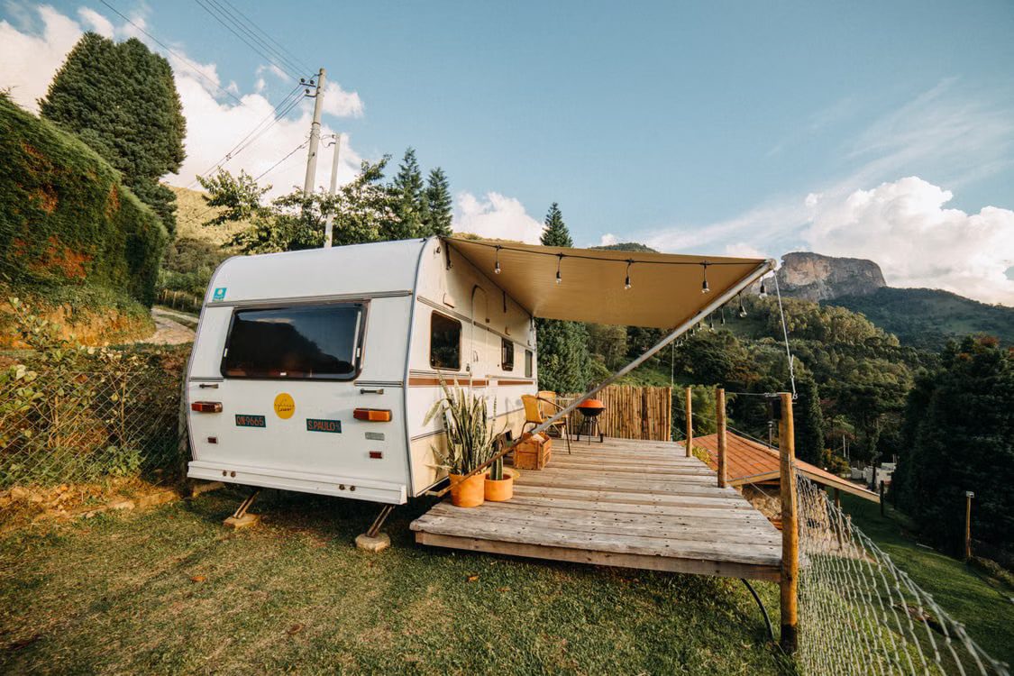 Travel trailer parked on a sloped mountain campsite, illustrating why RV leveling matters.