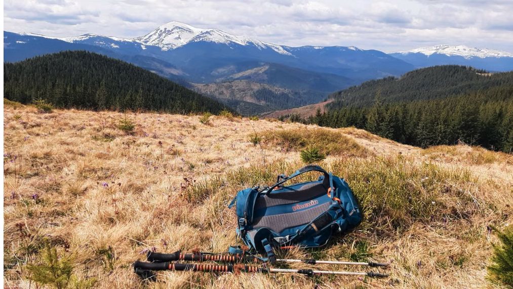 Backpack and trekking poles overlooking the Carpathian Mountains.