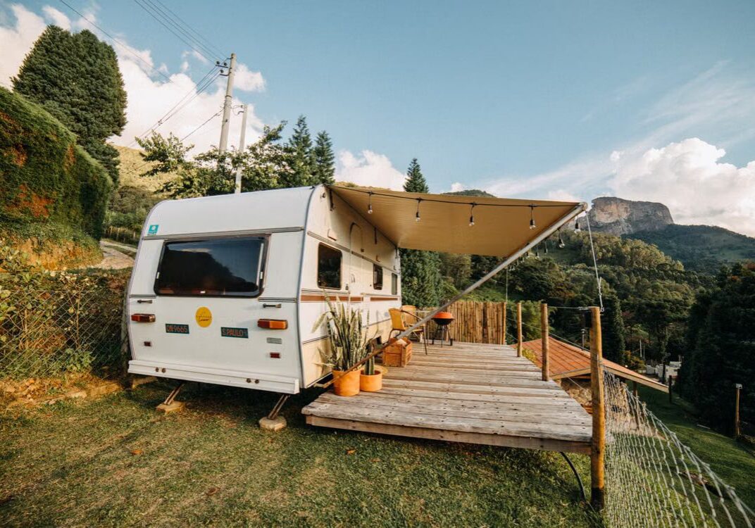 Travel trailer parked on a sloped mountain campsite, illustrating why RV leveling matters.
