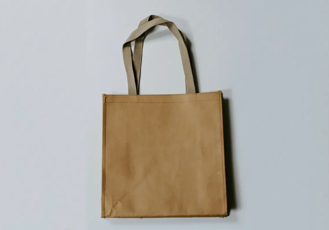 Brown reusable shopping bag on gray background.