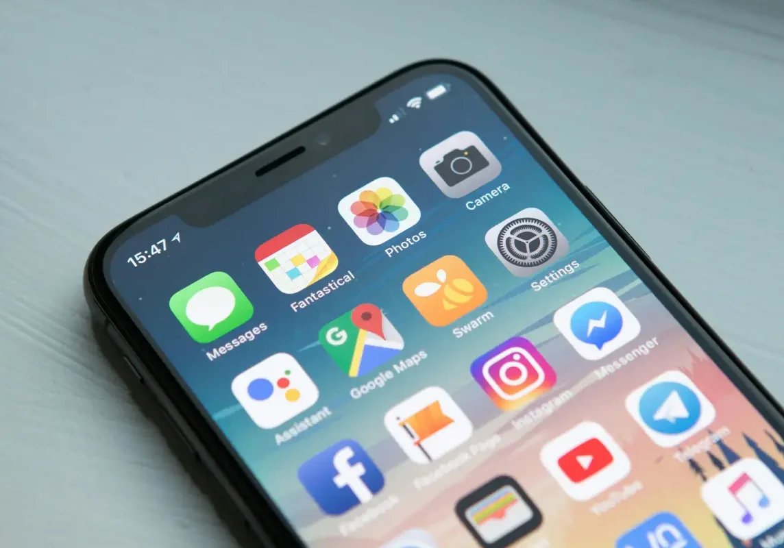 Smartphone displaying various app icons on screen.
