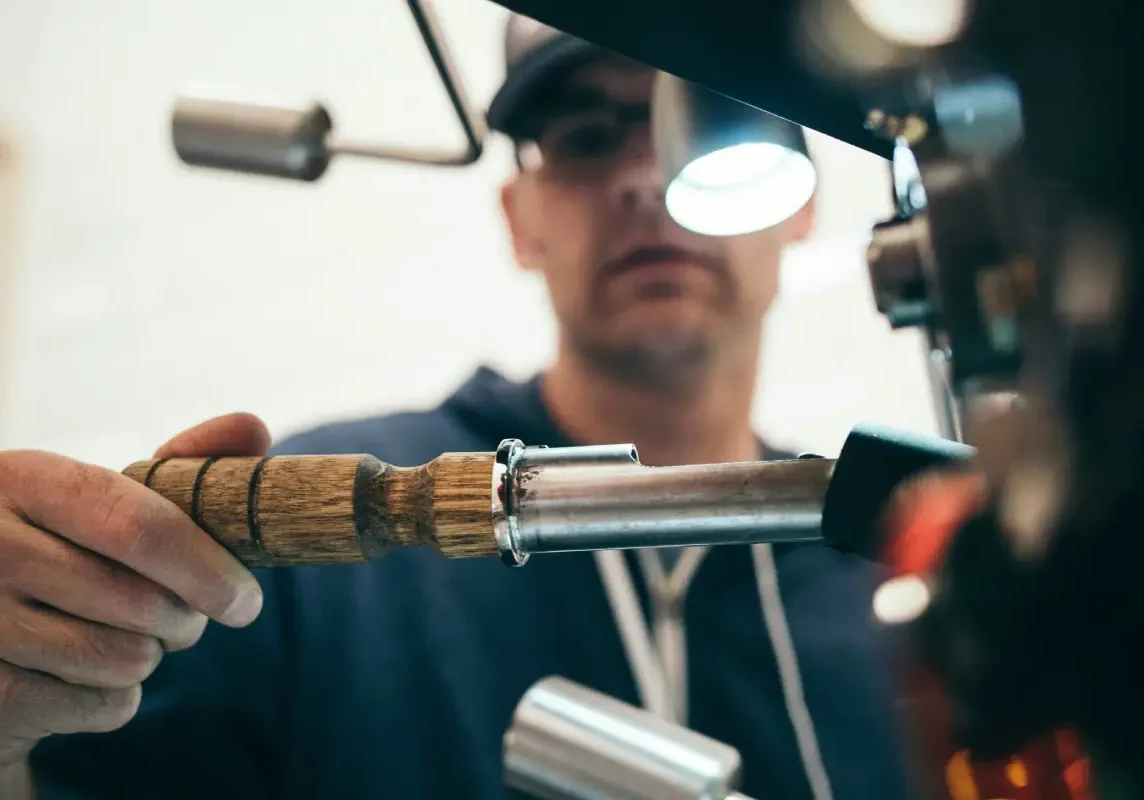 Person operating a coffee roasting machine.